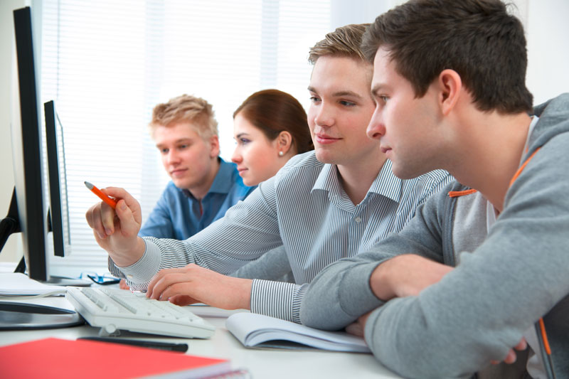 Students looking at a computer monitor together
